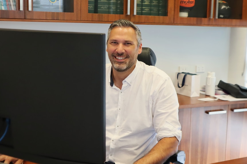 Leichardt MP Matt Smith smiling behind the computer.