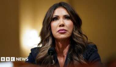 Kristi Noem attends a House Homeland Security hearing, she stares above the camera in a serious expression.