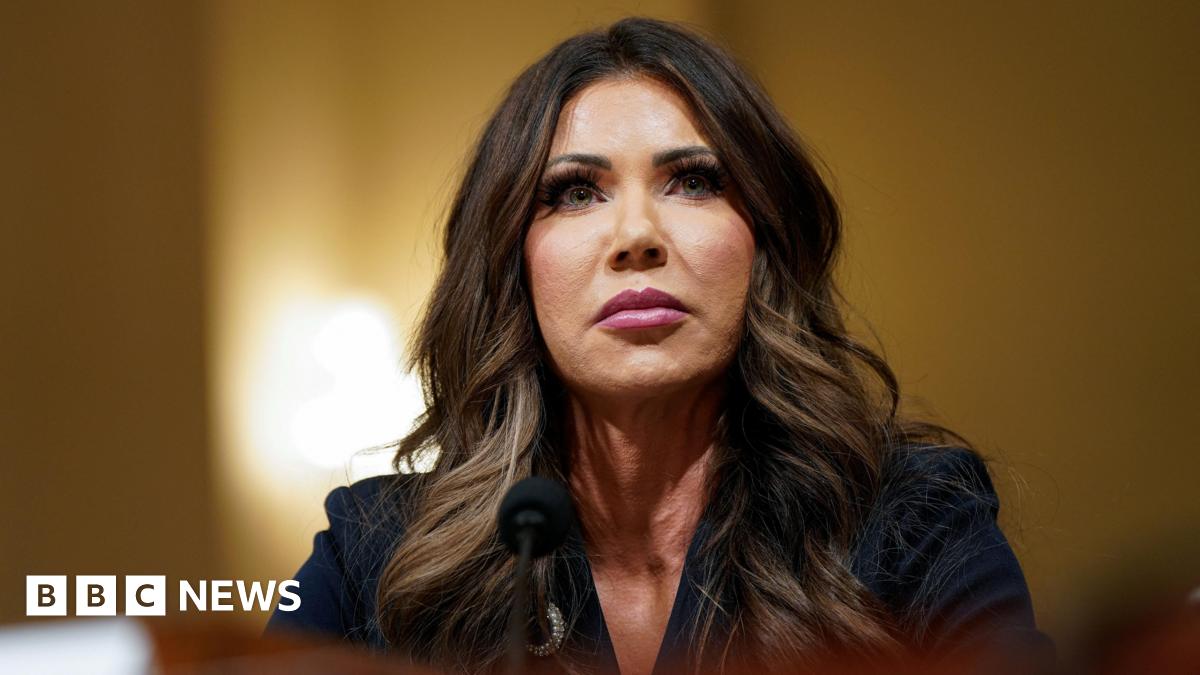 Kristi Noem attends a House Homeland Security hearing, she stares above the camera in a serious expression.