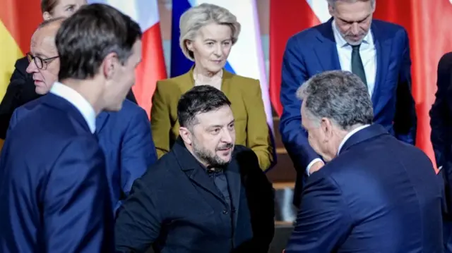 Ukraine's President Volodymyr Zelensky and US Special Envoy Steve Witkoff talk to each other as Jared Kushner, the son-in-law of US President Donald Trump, and European Commission President Ursula von der Leyen look on following a family photo opportunity at the Chancellery in Berlin, Germany, 15 December 2025