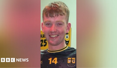 Pádraig McDonald. He has short ginger hair, wearing a black and yellow football top.