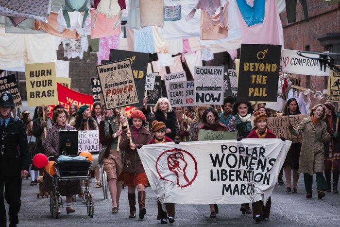 Call the Midwife characters on a Poplar women's liberation march, holding signs and placards.