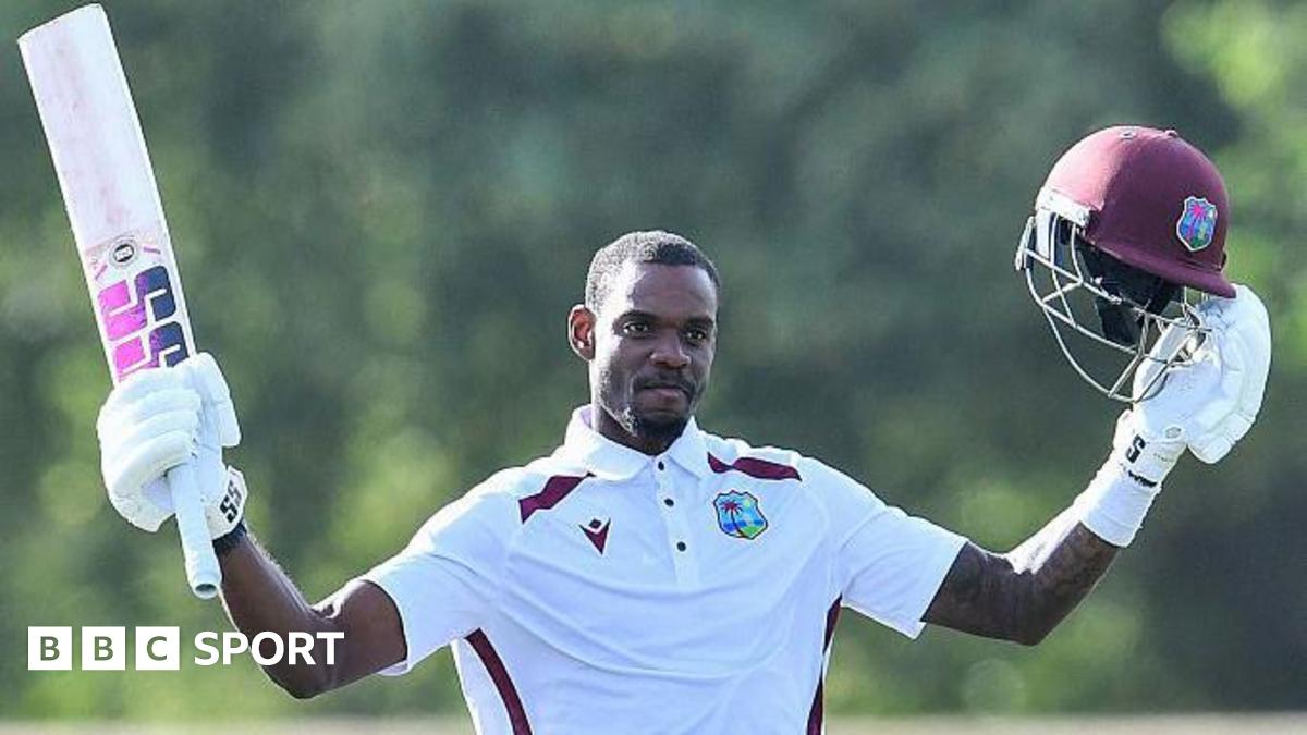 Justin Greaves holds his bat and helmet aloft after reaching 200