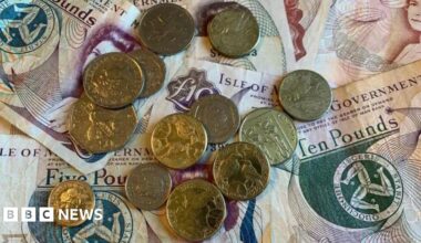 Manx money, notes and coins, laid flat on a table.