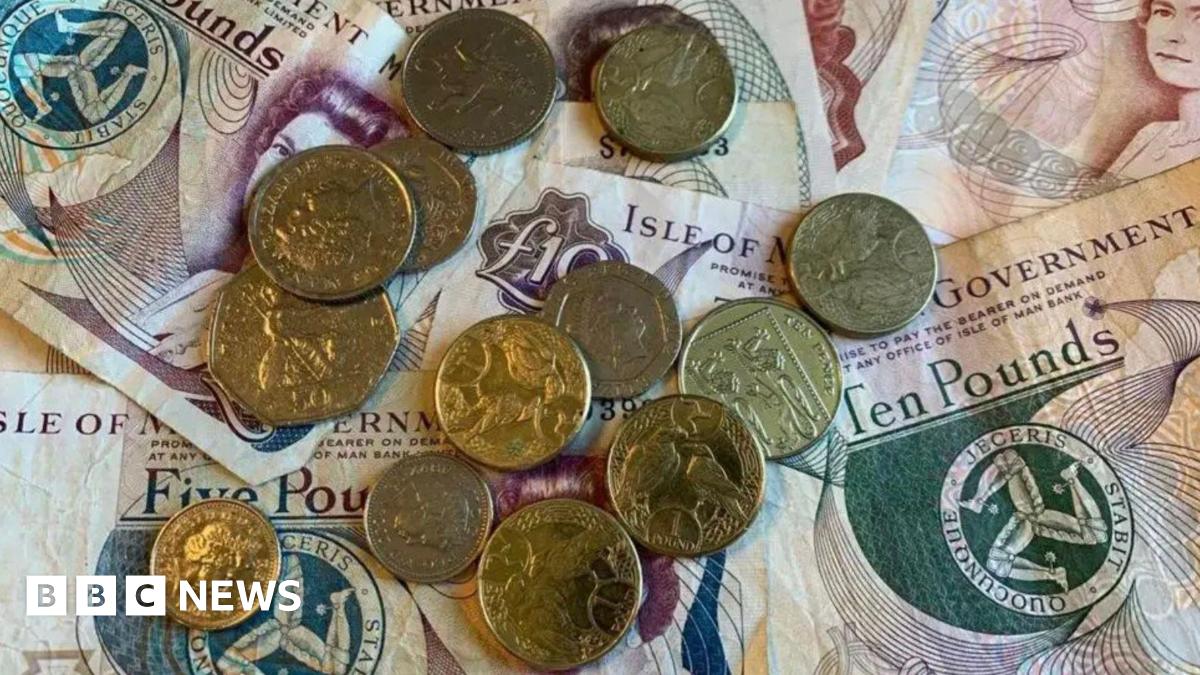 Manx money, notes and coins, laid flat on a table.