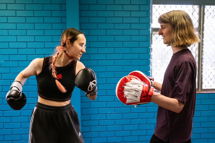 Participants smiling in a boxing class.
