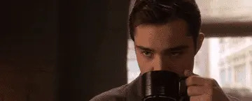 A man drinking a mug of coffee.