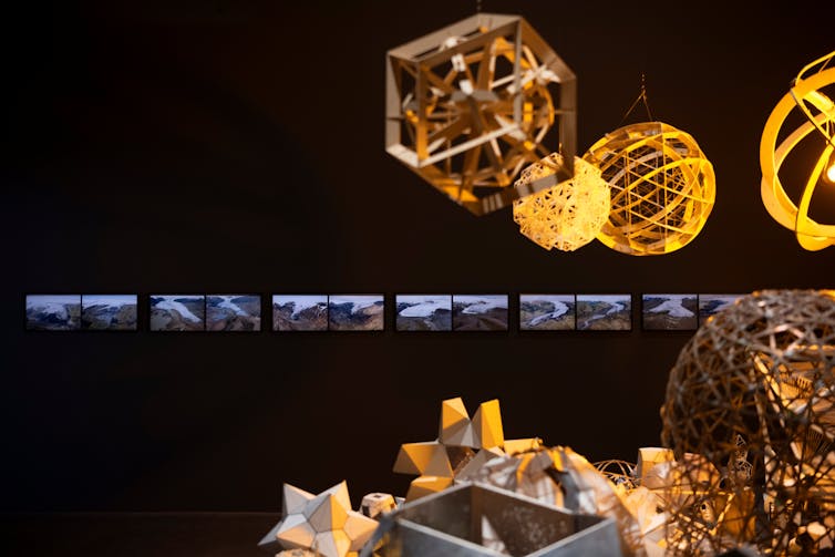 Gold geometric spheres in front of photos of glaciers.