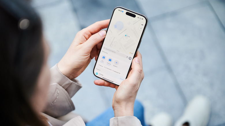 Person uses smartphone to navigate map application.