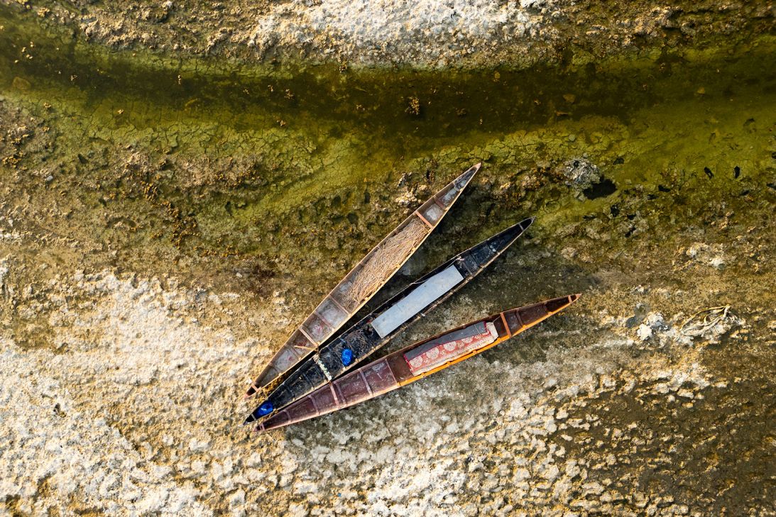 Traditional wooden fishing boats lie abandoned in dried-up marshes in Iraq's southern Basra province on September 4, 2025.