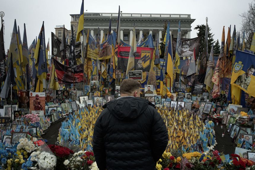 A man stands near rows of small flags installed in a designated area honoring fallen soldiers of the Azov Brigade of Ukraine's National Guard at a spontaneous memorial at Maidan Nezalezhnosti, Ukraine's Independence Square, on December 21, in Kyiv, Ukraine.