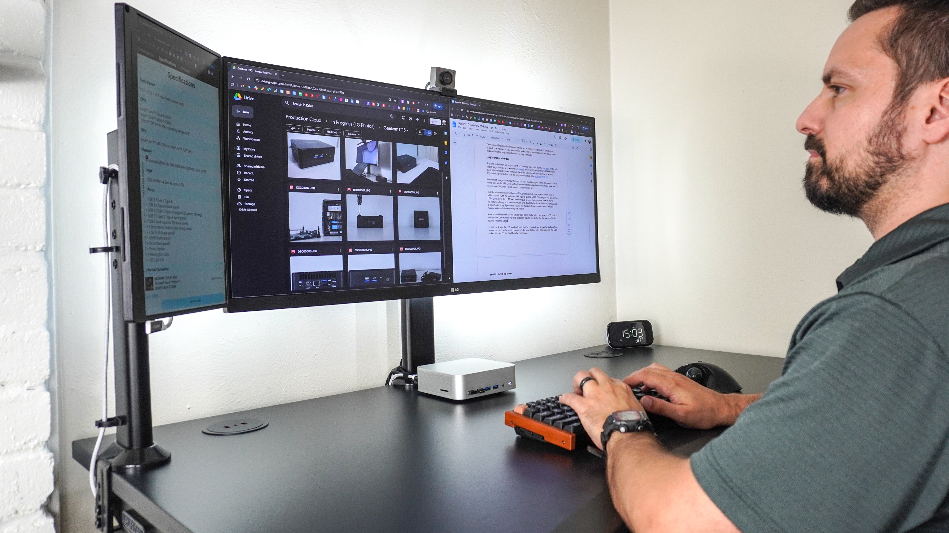 A person working on a desk setup with a portable monitor next to an ultrawide display