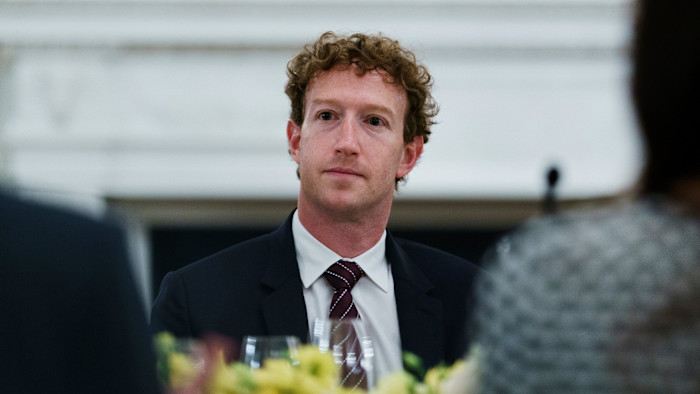 Mark Zuckerberg sits at a dinner table, looking ahead, during a gathering with tech leaders at the White House.