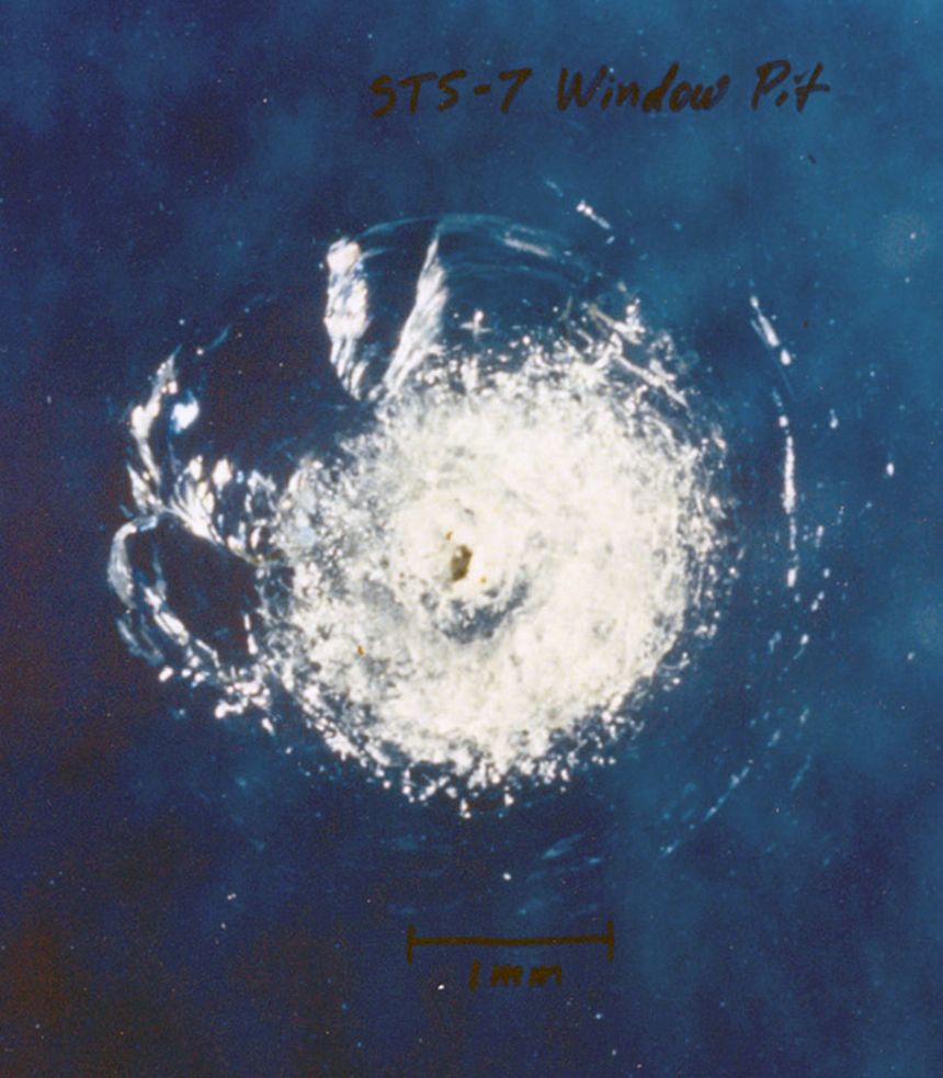 Damage to the window of the Challenger space shuttle caused by a piece of space junk in 1983.