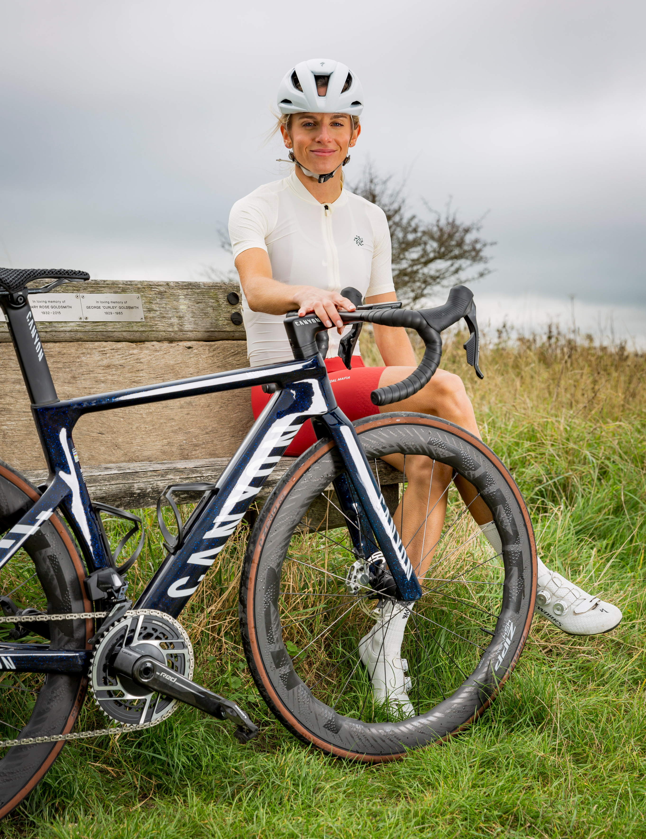 Georgia Hunter Bell on a bench holding a bike
