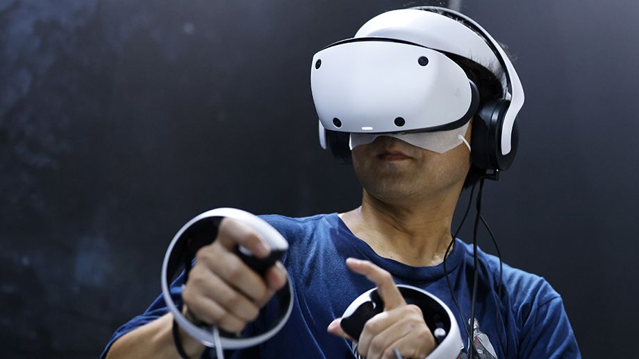 Man playing with Sony PSVR 2 VR headset and controllers