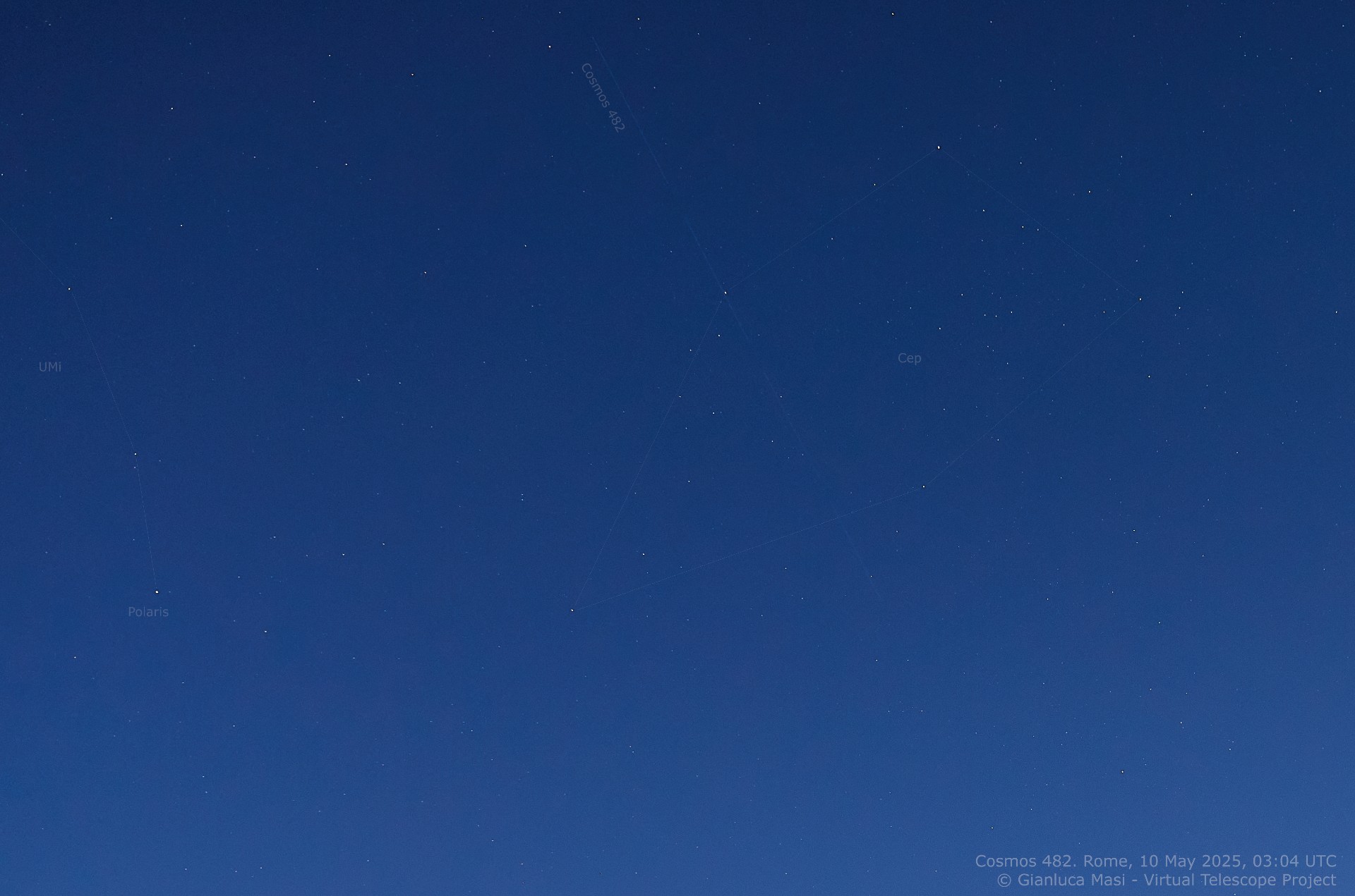 a faint line of light crosses a starry night sky at dusk