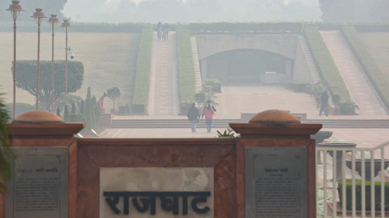 People visit the Rajghat as a layer of smog engulfs the city amid deteriorated air quality.