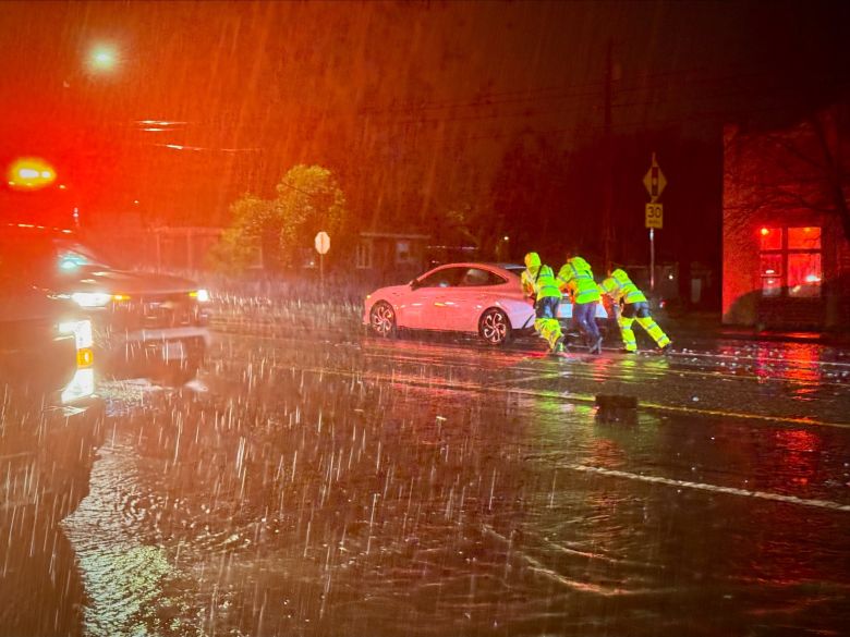 First responders push a car during torrential rain in Redding, California, early Monday morning.