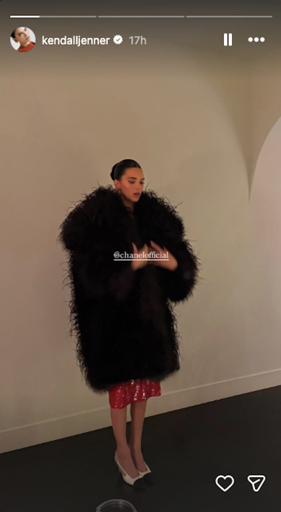 model wearing a dramatic black coat and a red dress