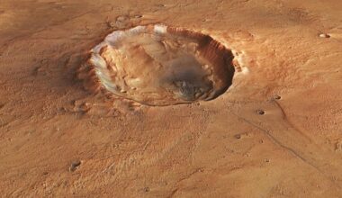 A photo of the surface of Mars from space, with a large crater seen in its reddish brownish surface