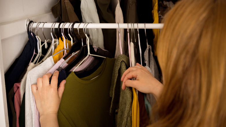 Woman looking through clothes on a rack.