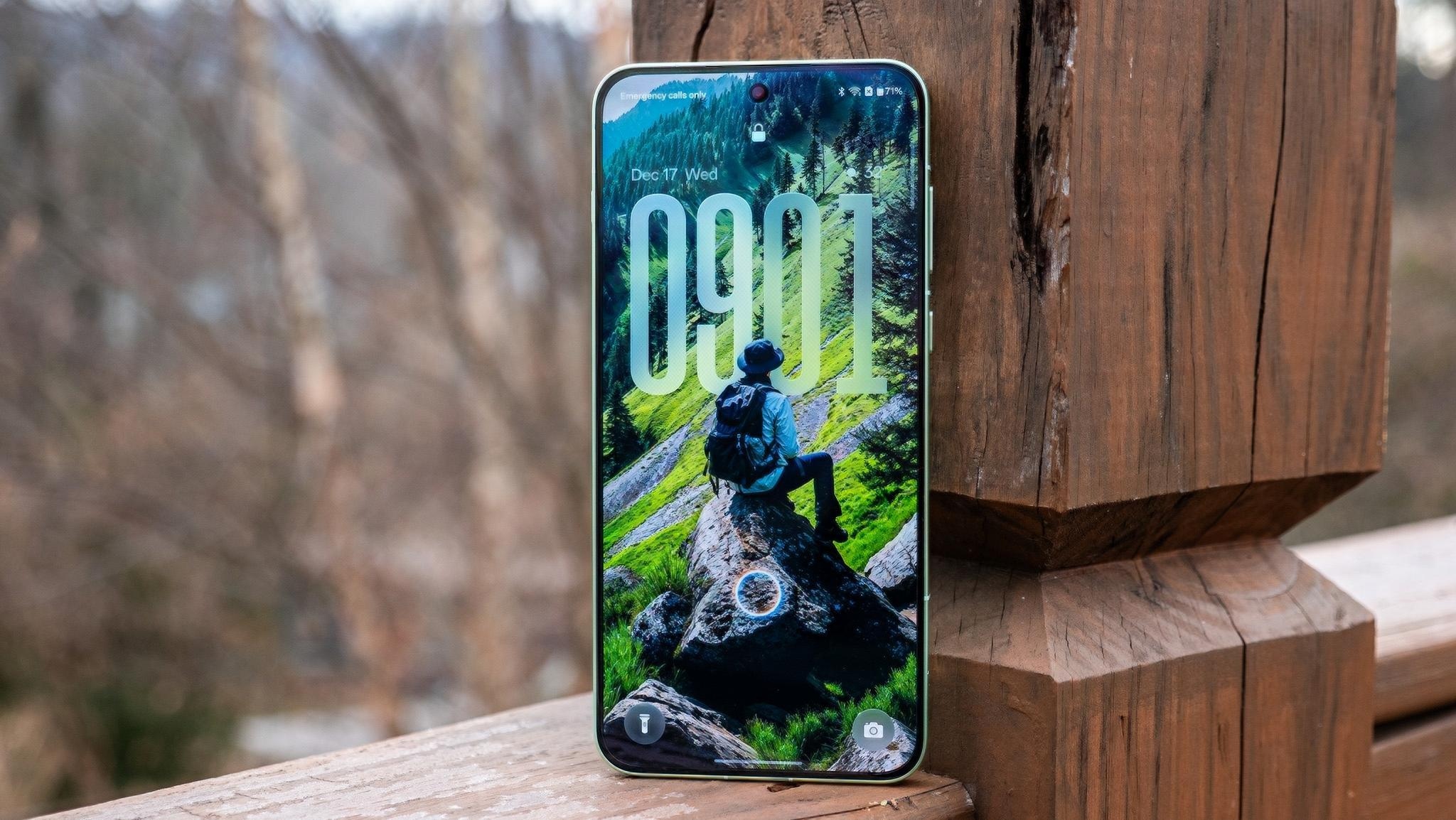 A OnePlus 15R with a Flux Themes forest wallpaper on the lockscreen