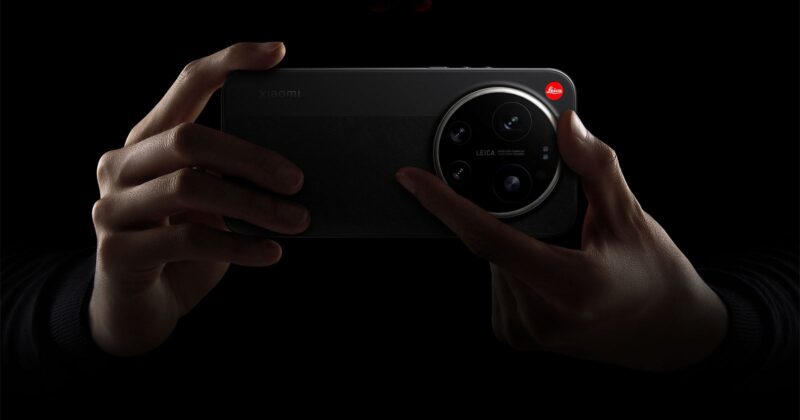 A person holds a Xiaomi smartphone with a large Leica-branded camera module, highlighted against a dark background.