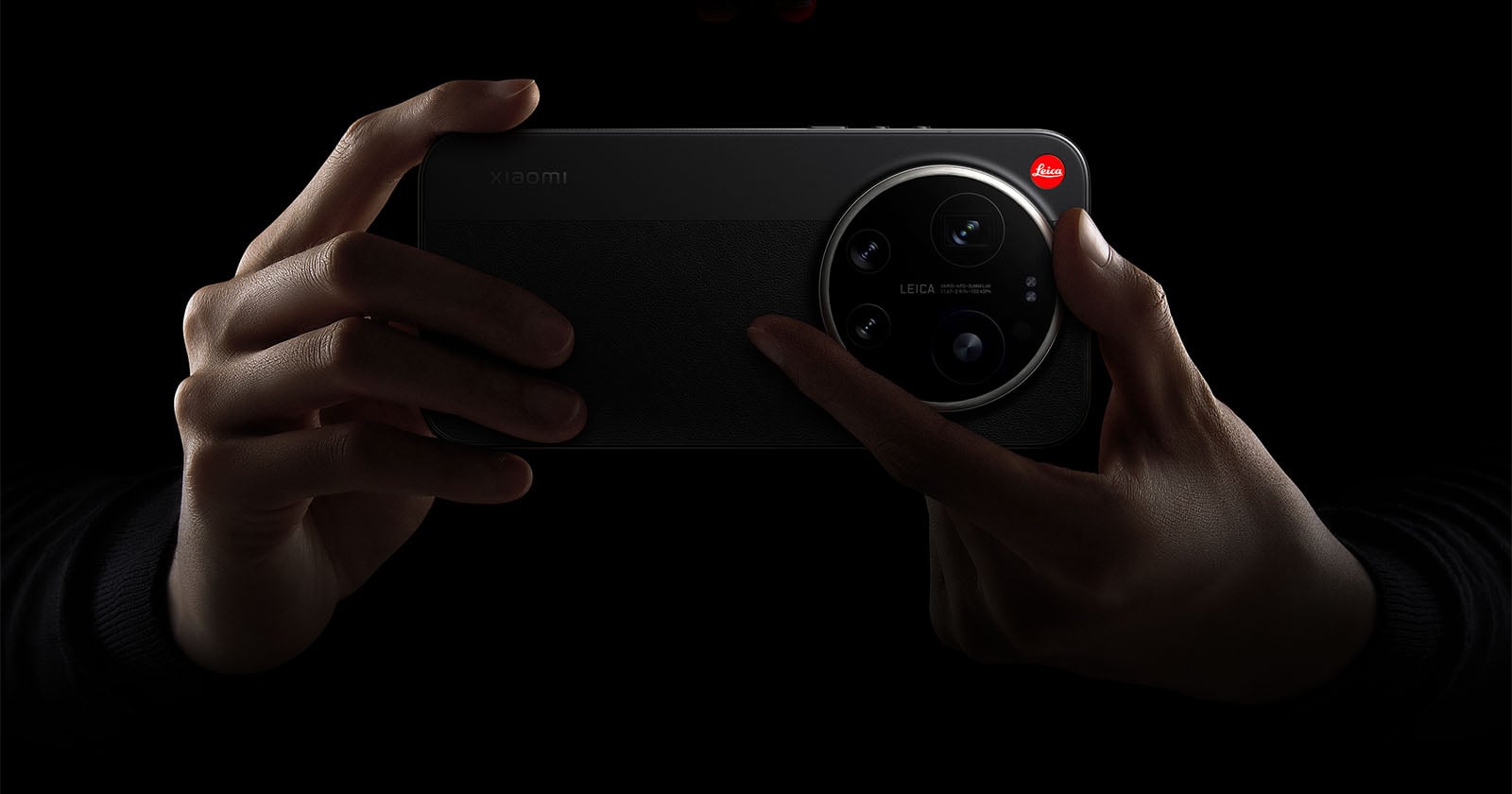 A person holds a Xiaomi smartphone with a large Leica-branded camera module, highlighted against a dark background.