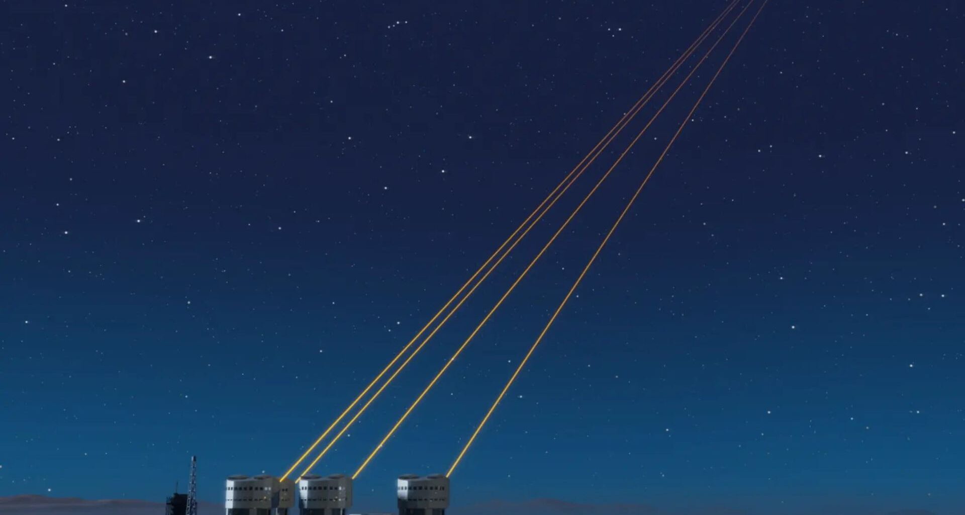 A series of small round buildings at the bottom left of the image with four yellow lasers pointing into the top right of the image over a dark blue night sky.