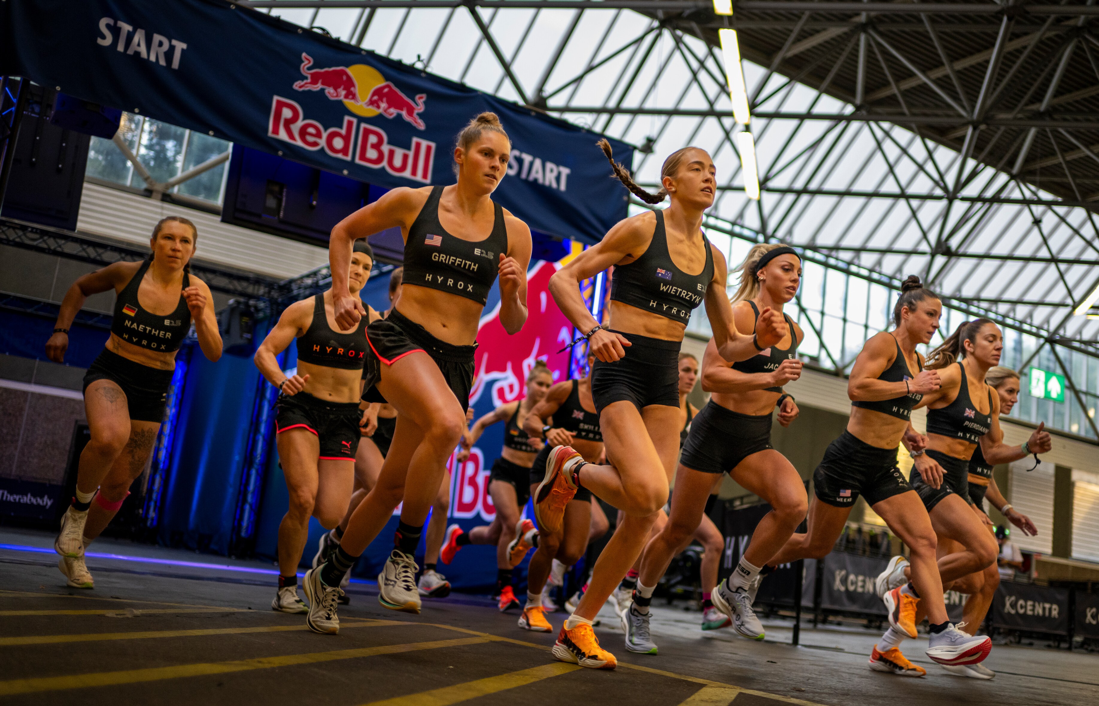 A group of female athletes in black sports bras and shorts competing in the HYROX Elite 15 race.