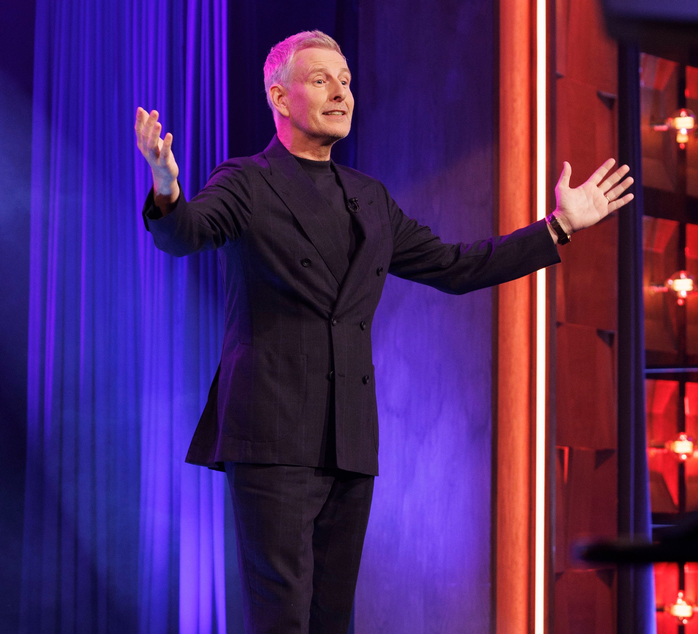 Patrick Kielty gesturing on The Late Late Show stage.
