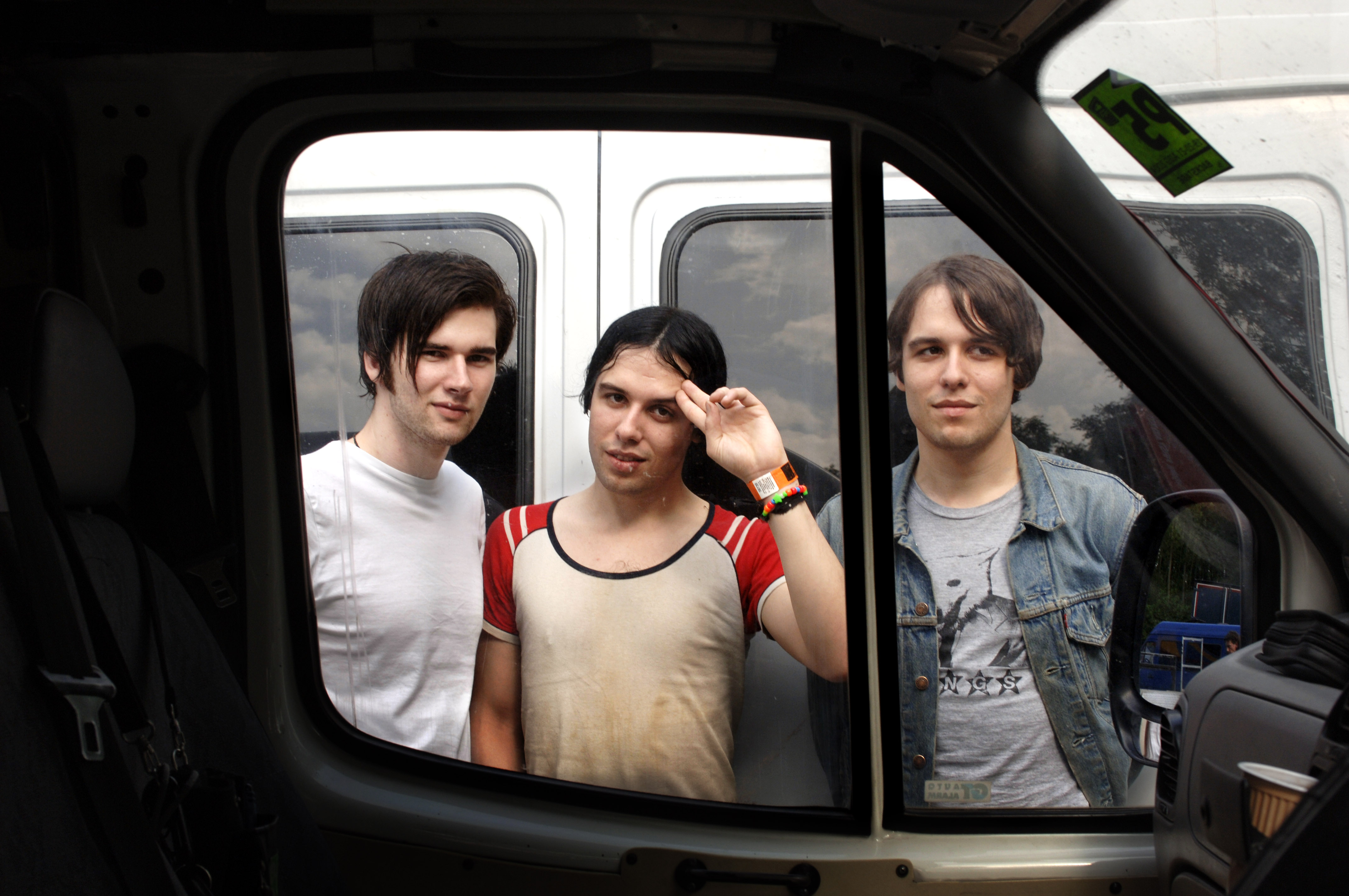 Ross, Ryan, and Gary Jarman of The Cribs viewed through the window of a transit van.
