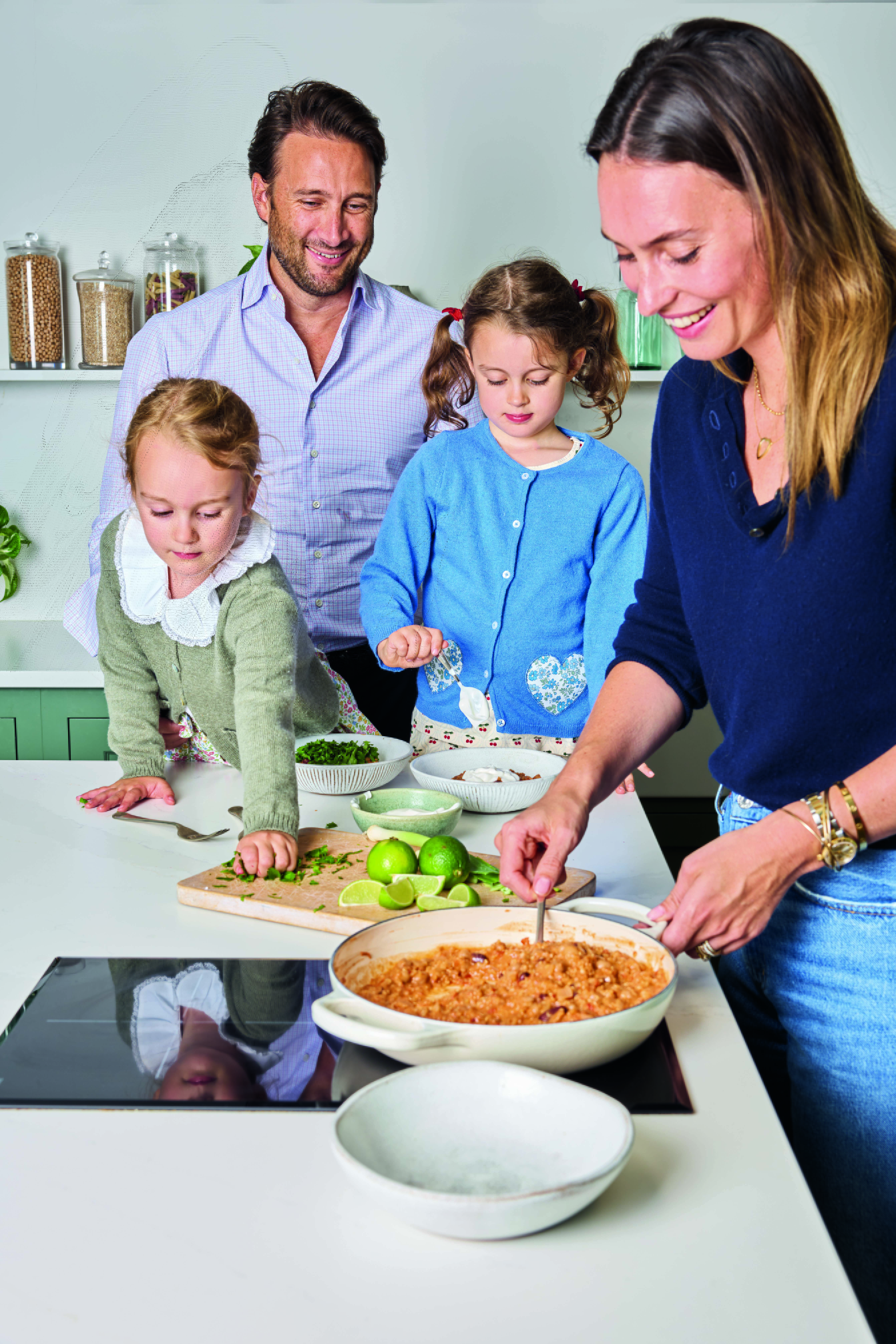 A family of four cooking in a kitchen.