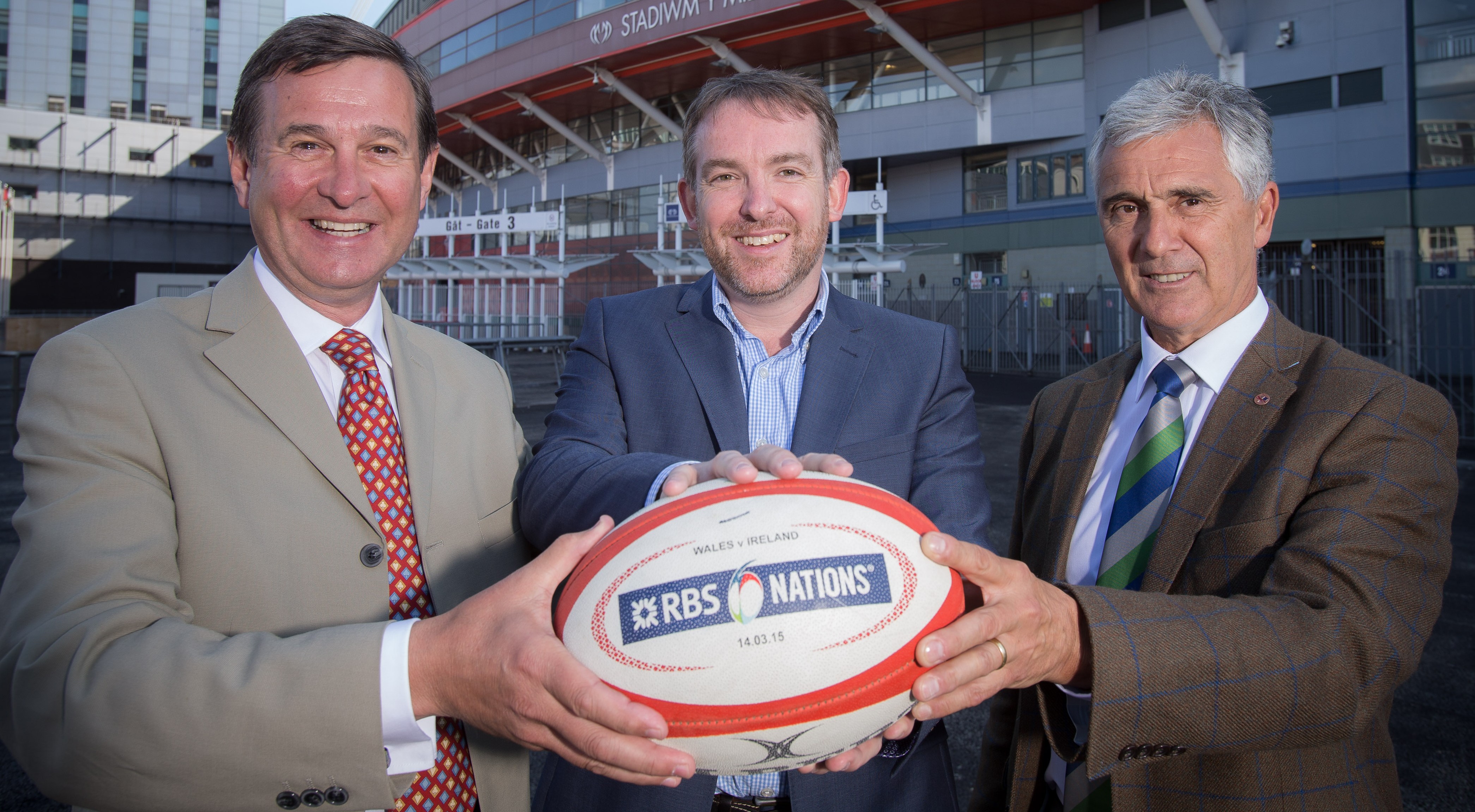 WRU Group Chief Executive Roger Lewis, BBC Wales Director Rhodri Talfan Davies, and WRU Chairman Gareth Davies holding a rugby ball at Millennium Stadium.