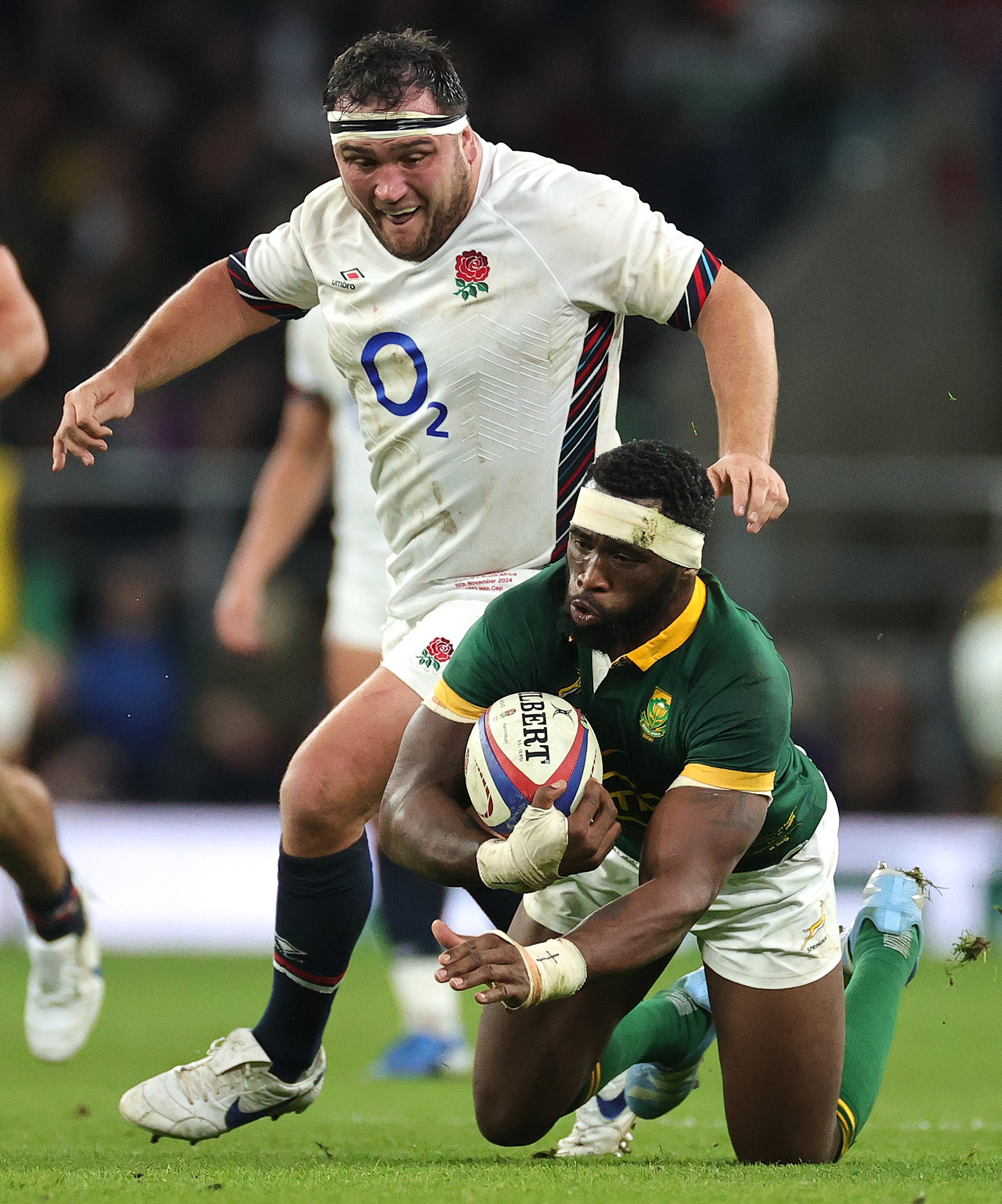 Siya Kolisi of South Africa with the ball as Jamie George of England challenges.