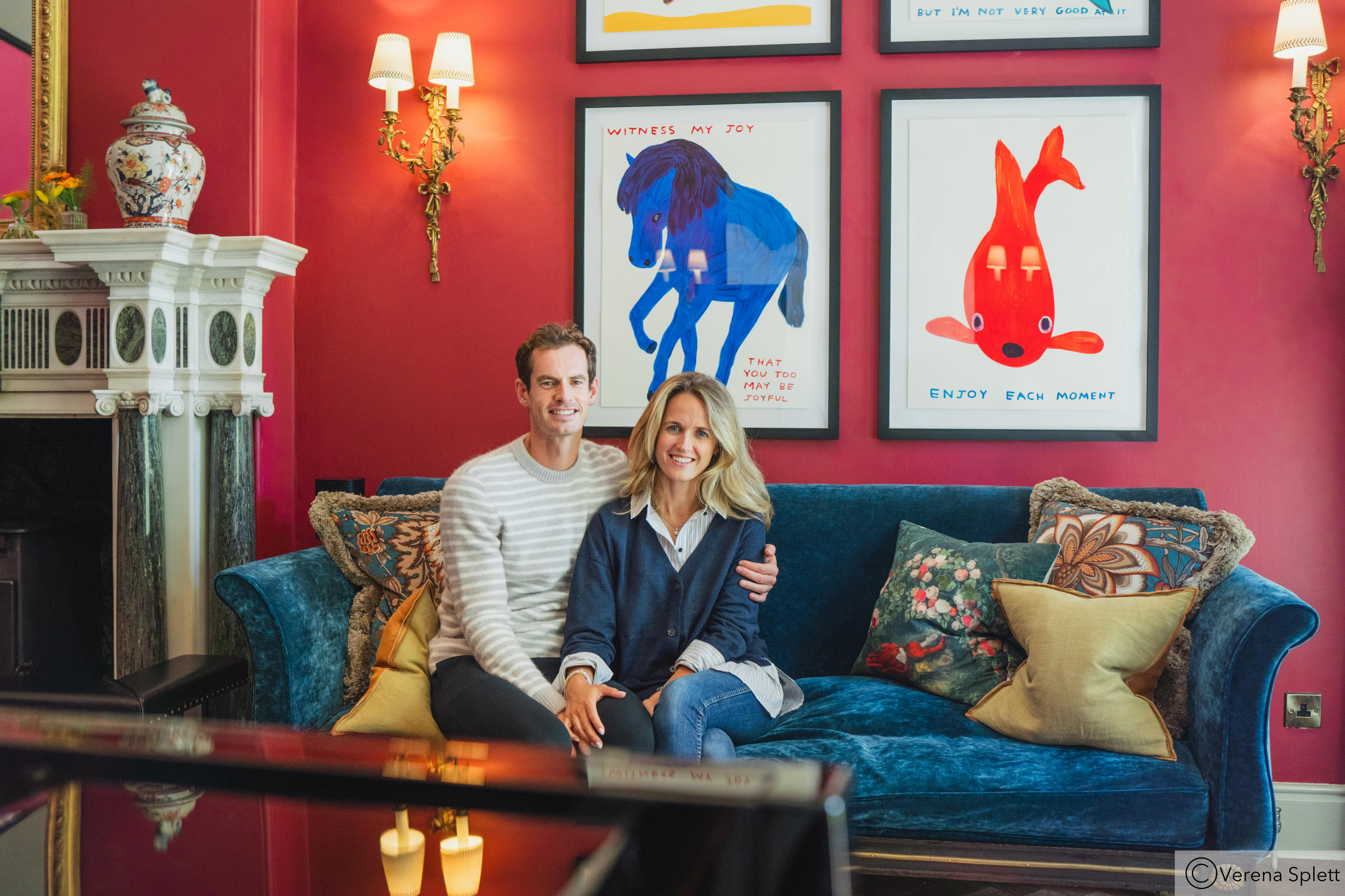 Andy Murray and his wife Kim Sears sitting on a blue couch in their hotel.