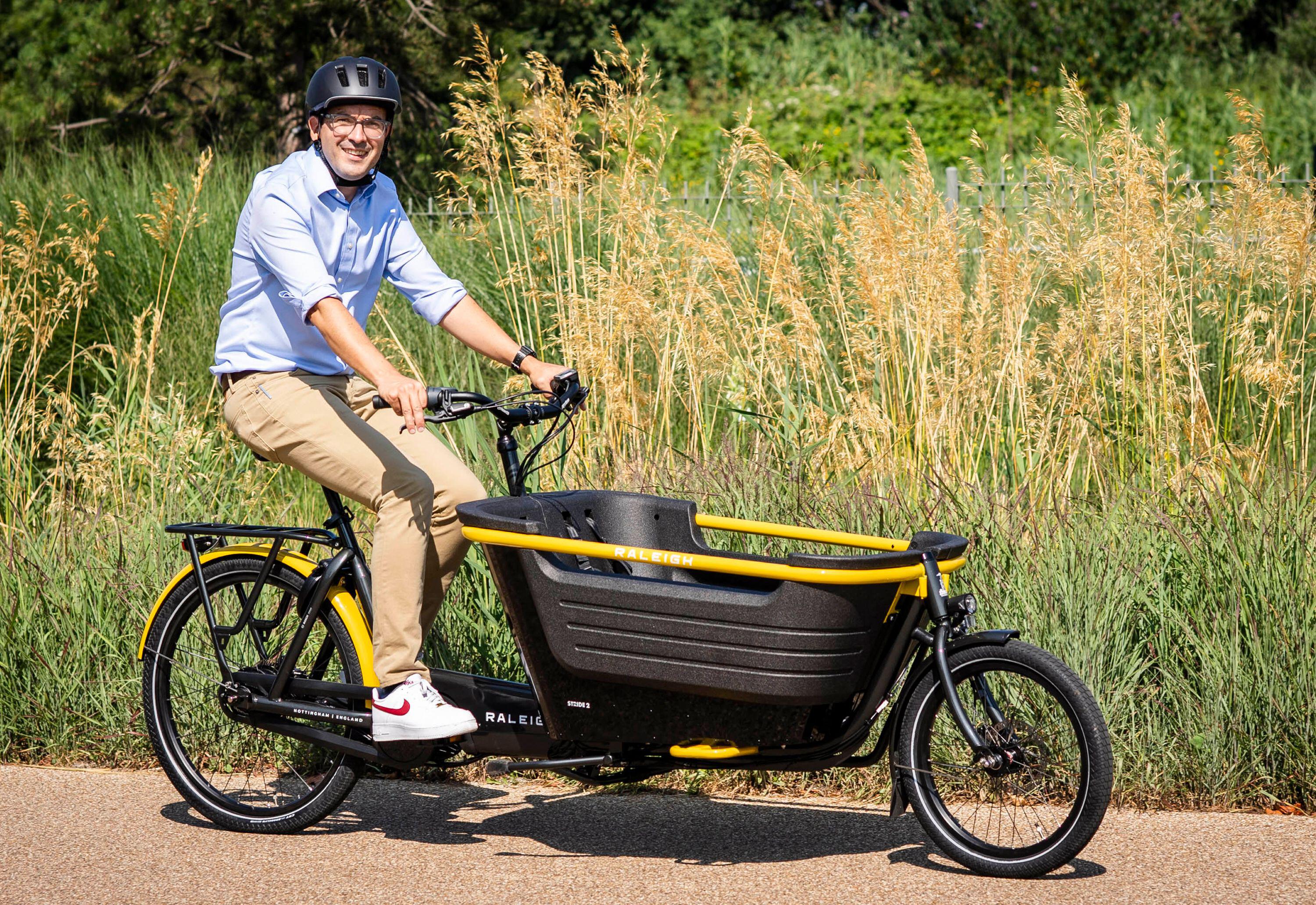 Will Norman, Mayor of London's Cycling and Walking Commissioner, on a Raleigh Stride E-cargo bike.
