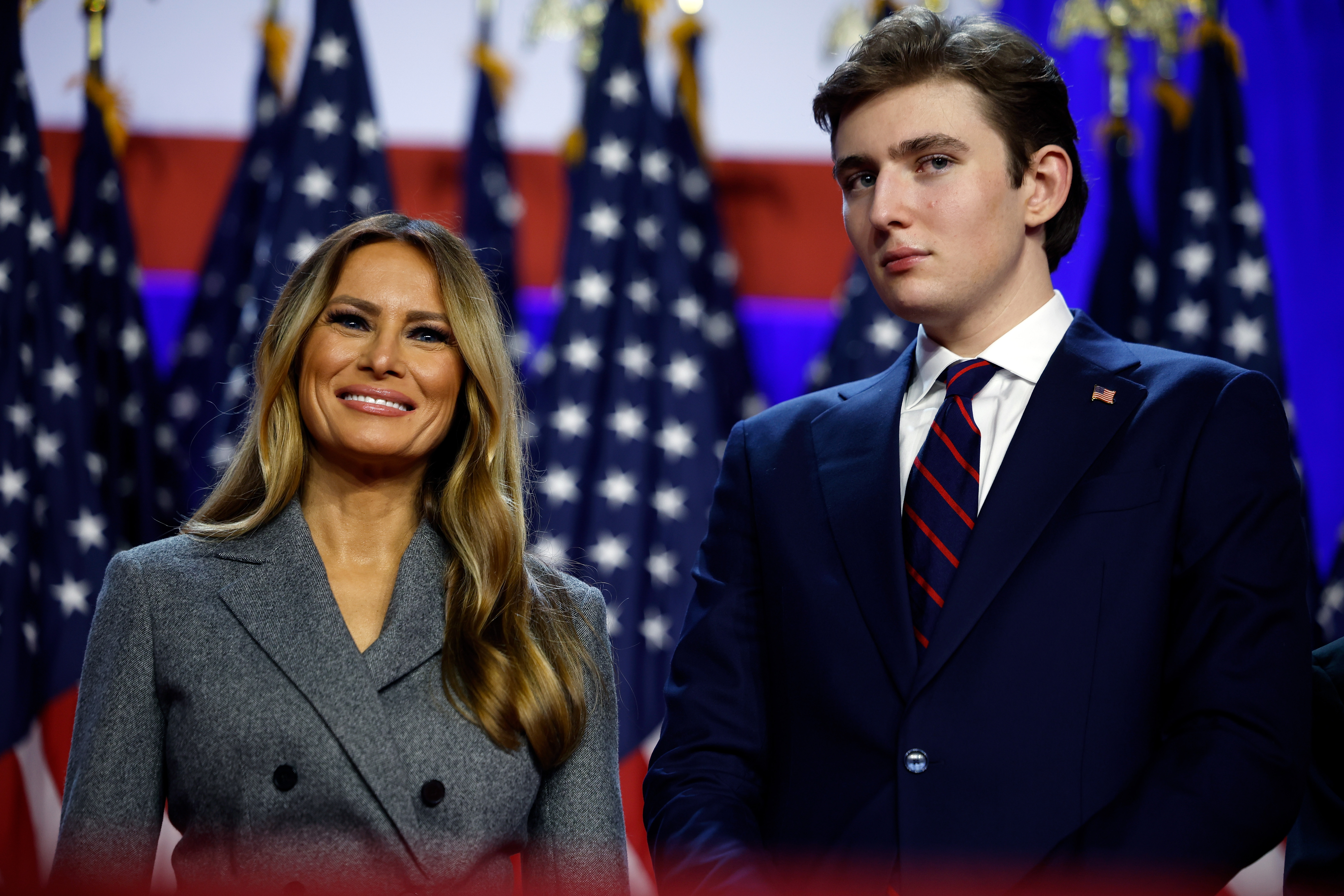 Melania Trump smiling and Barron Trump looking on during an election night event.