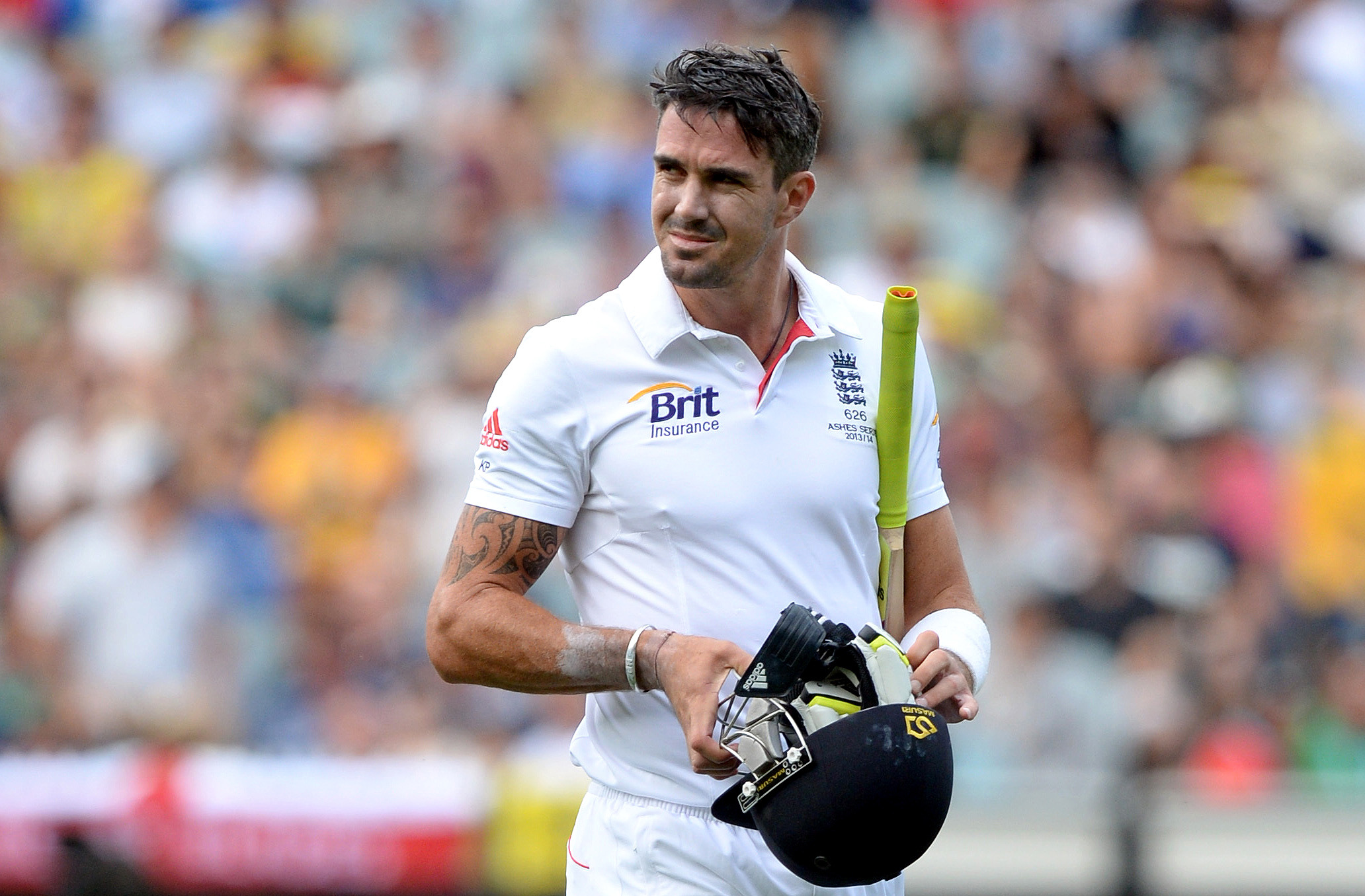 England cricketer Kevin Pietersen in uniform, holding a helmet and a bat.