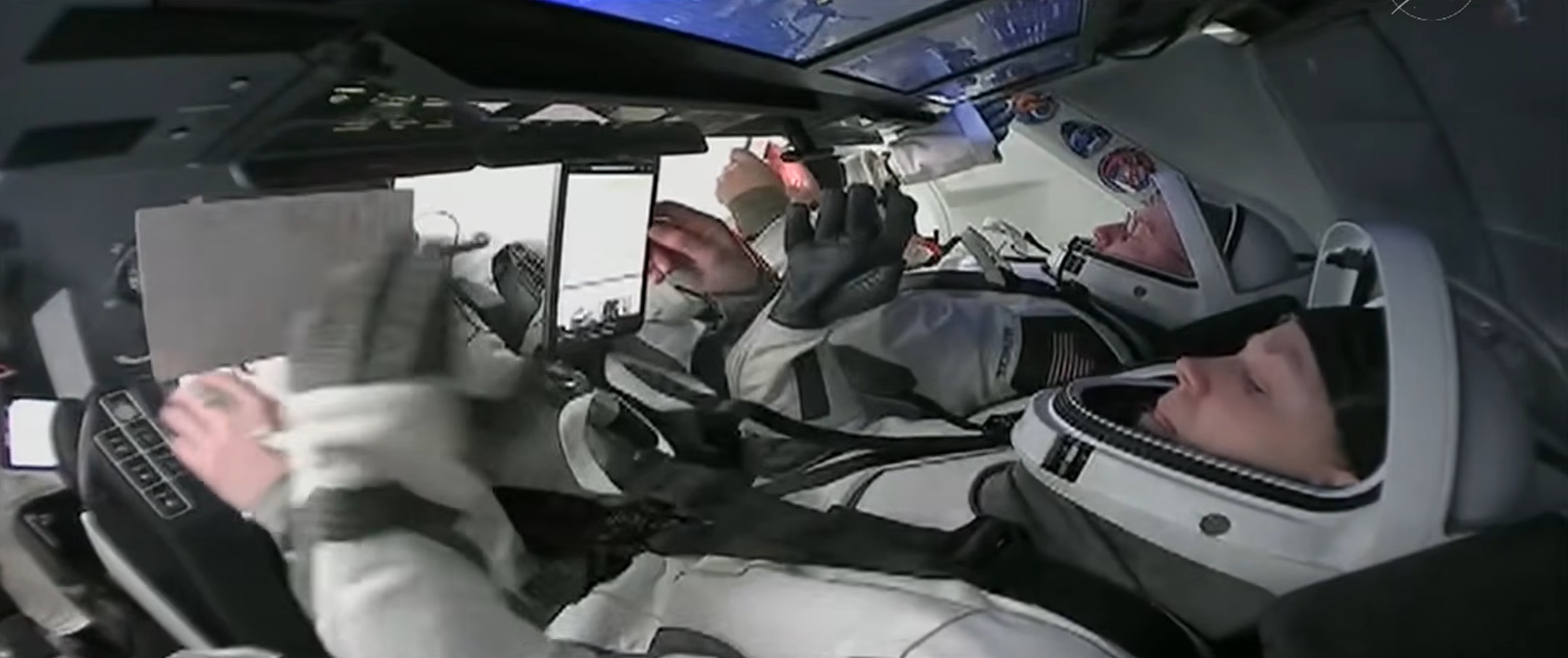 Astronauts in white spacesuits preparing for the SpaceX Crew-11 hatch closing.