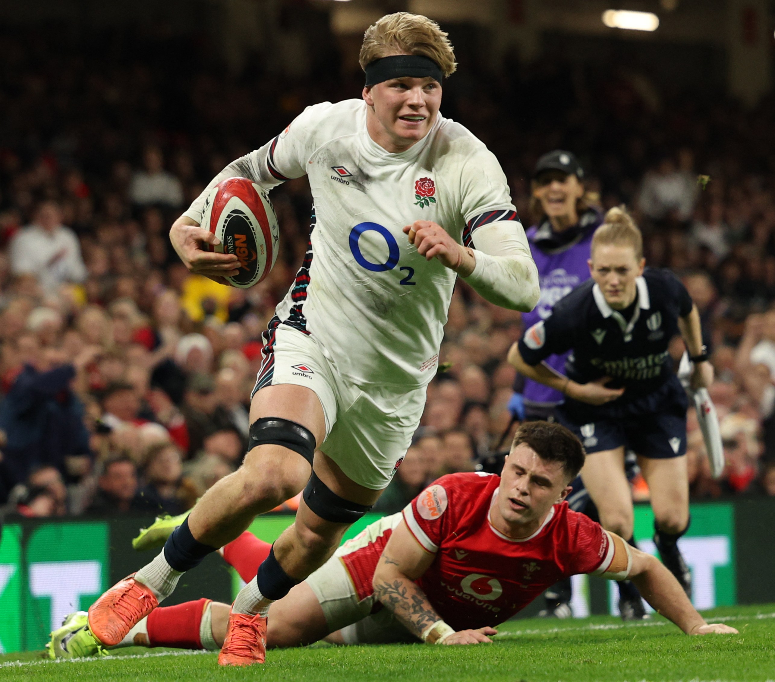 England's Henry Pollock evades a tackle from Wales' Joe Roberts during a rugby match.