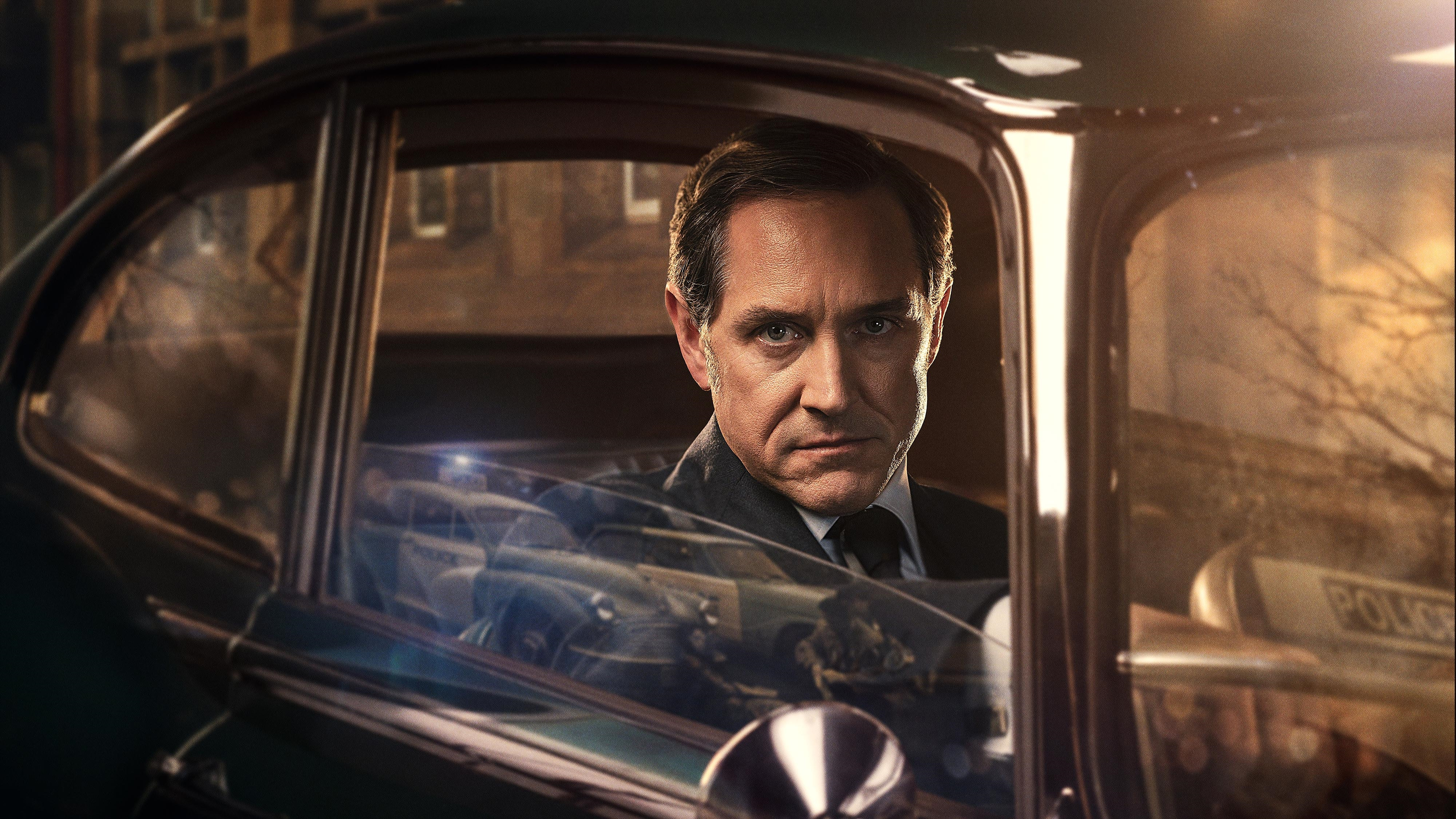 Bertie Carvel as Dalgliesh, looking directly at the viewer from inside a car.