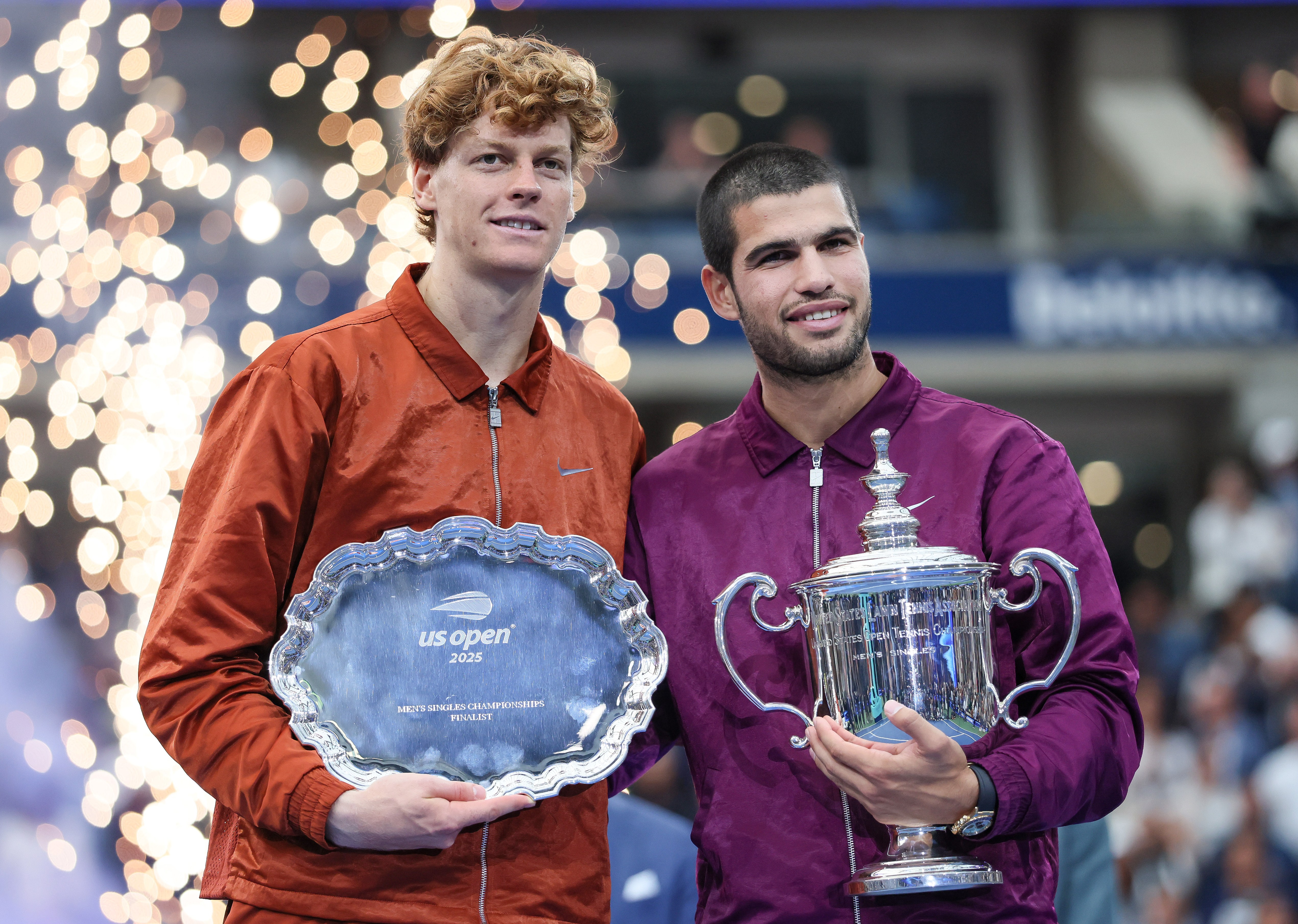 Carlos Alcaraz and Jannik Sinner holding their trophies at the US Open.