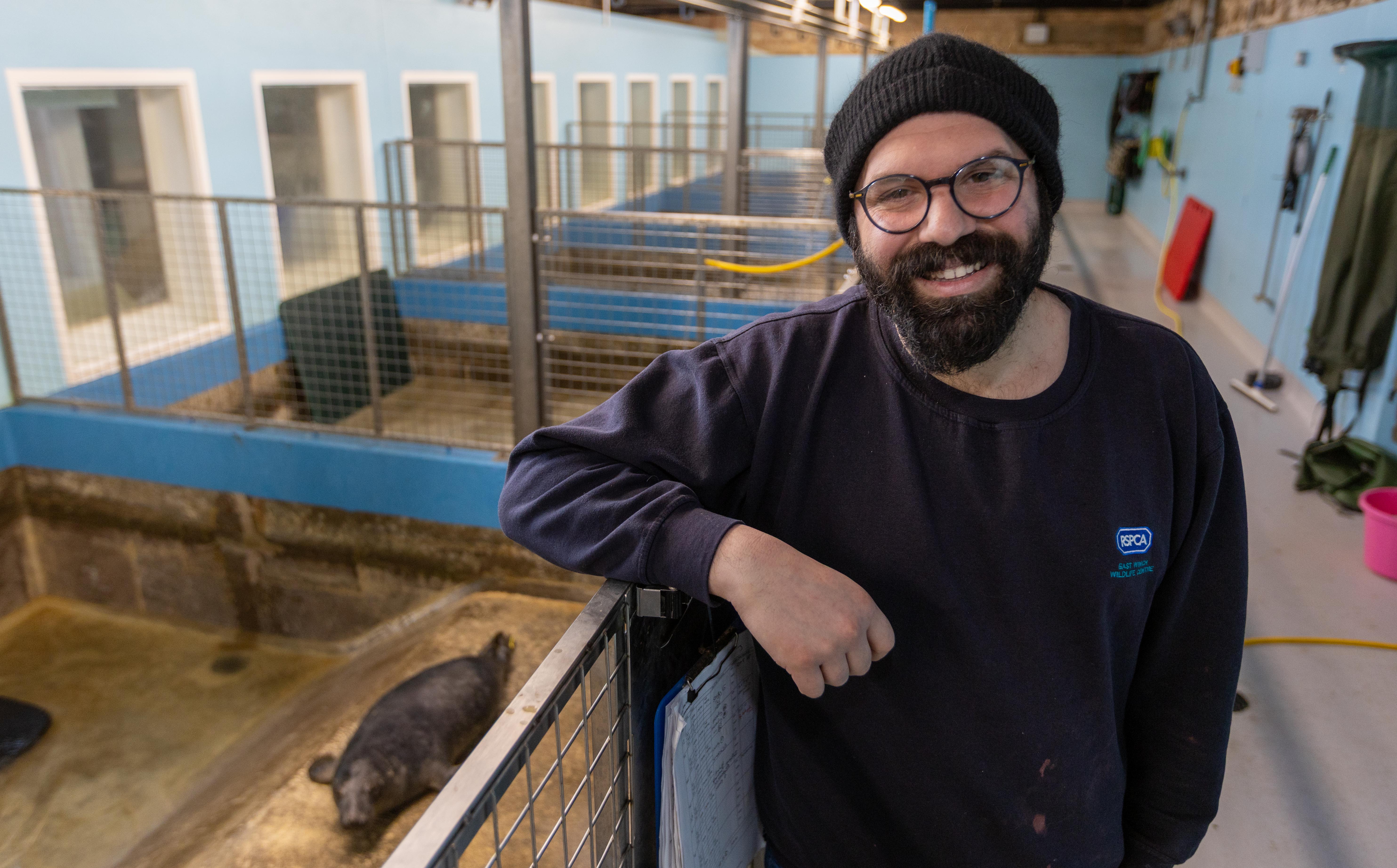Wildlife Centre Manager Evangelos Achilleos smiles while standing by a seal enclosure in Norfolk.