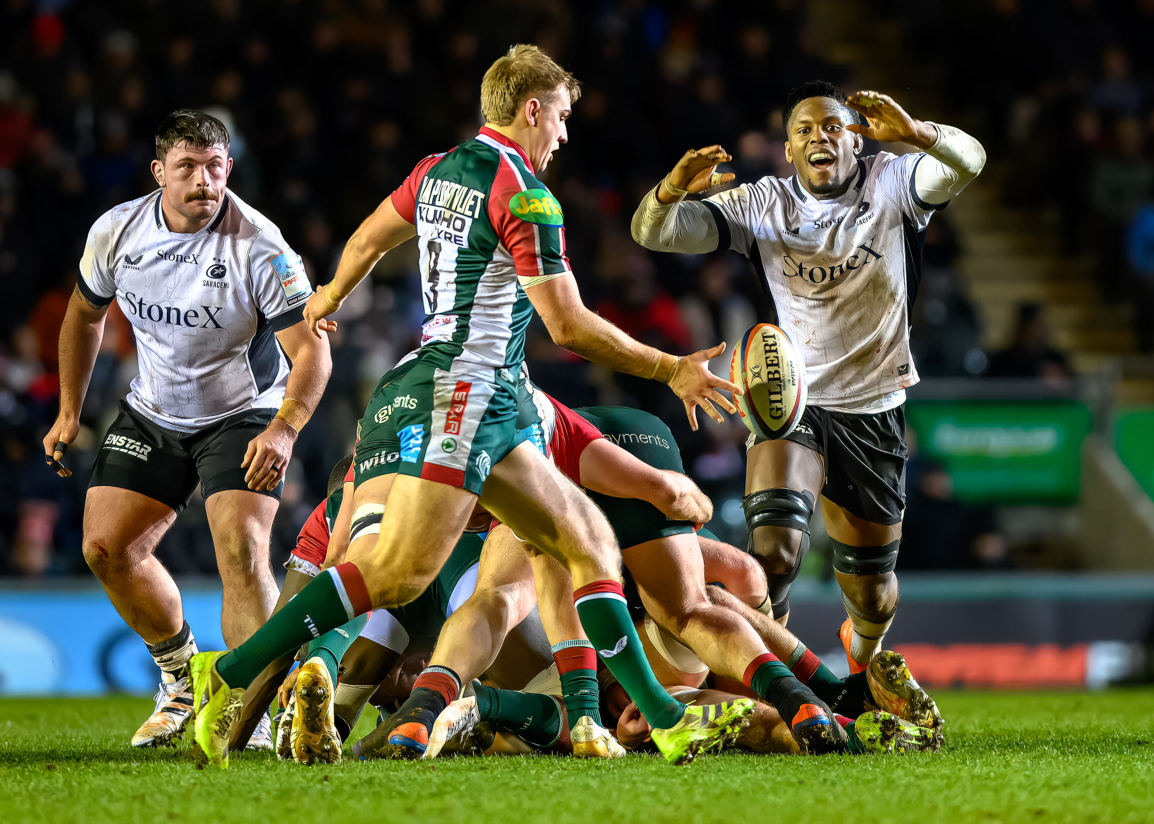Jack Van Pootvliet (Tigers) kicking the ball with Maro Itoje (Saracens) attempting to block during a rugby match.