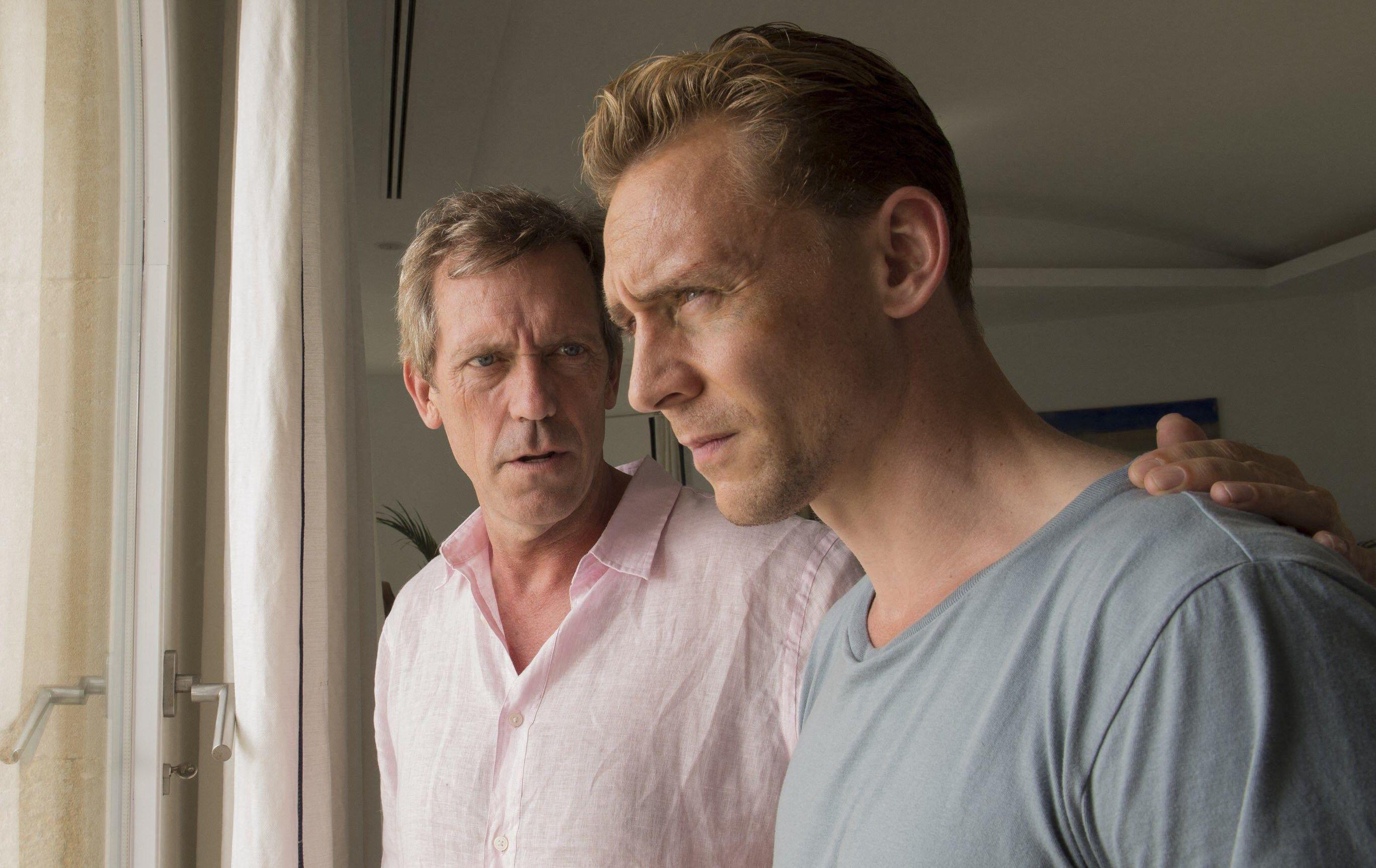 Hugh Laurie with a concerned expression, and Tom Hiddleston with an intense expression, from the TV series "The Night Manager."