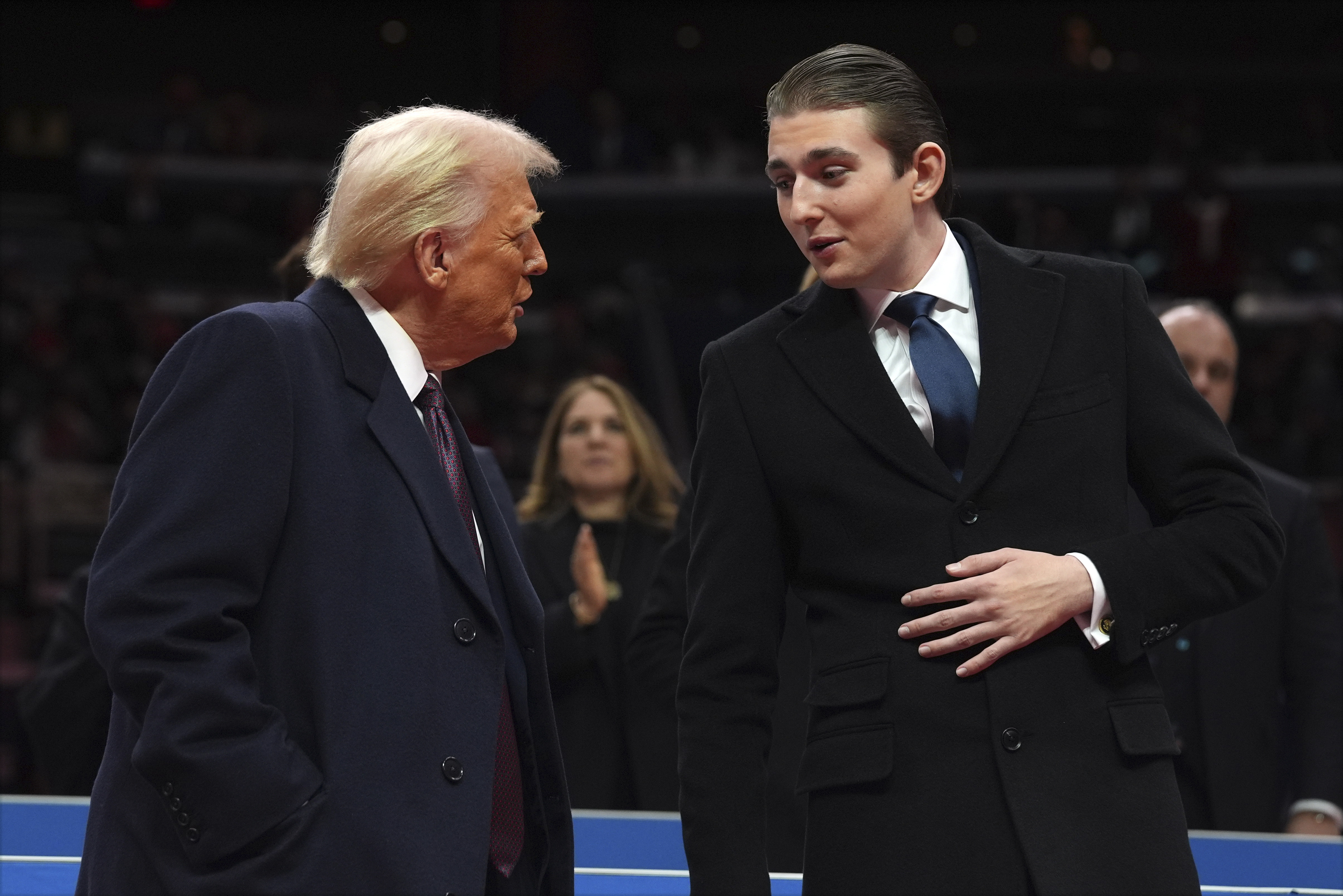 Donald Trump talking to his son Barron at an indoor Presidential Inauguration parade.