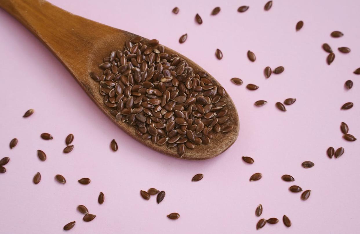 flax seed in spoon on pink background