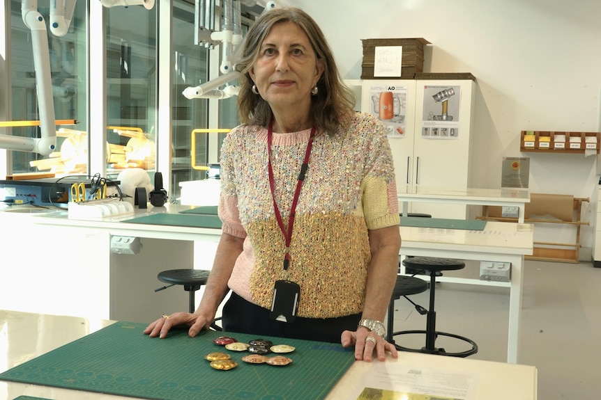 Woman stands over coffee pods